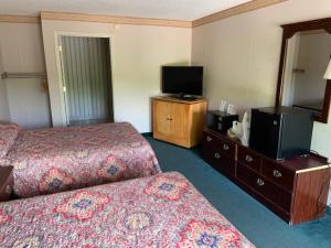 a hotel room with two beds and a flat screen tv at Executive Inn Yanceyville in Yanceyville