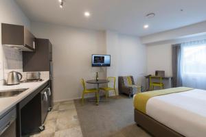 a hotel room with a bed and a kitchen at Quest on Thorndon in Wellington