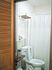 a bathroom with a toilet with a shower curtain at Rustic Guest House in Chiang Mai