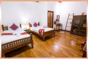 1 dormitorio con 2 camas y suelo de madera en Rustic Guest House, en Chiang Mai