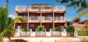 a large pink building with a balcony at Caye Caulker Condos in Caye Caulker