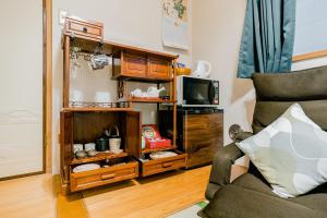 a living room with a couch and a tv at Hakusan House in Tokyo