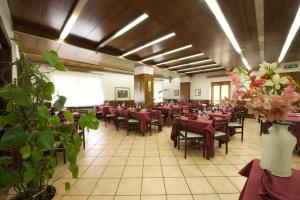 a dining room with tables and chairs and flowers at Hotel Caldora in Rocca di Mezzo