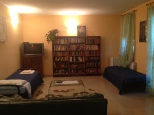 a living room with two beds and a book shelf at Villa Naclerio in Sarzana