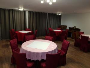 a room with tables and chairs and a piano at Hotel Krone UG in Deißlingen