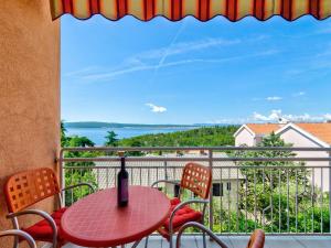a table and chairs on a balcony with a view of the ocean at Apartment Nenad in Dramalj
