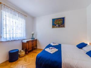 a bedroom with a blue bed and a window at Apartment Nenad in Dramalj