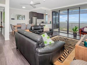 Una sala de estar con un sofá de cuero y una mesa. en Luxury waterfront sea view apartment - do not book, en Cairns