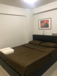 um quarto com uma cama e um quadro na parede em Me Apartment em Ban Talat Rangsit