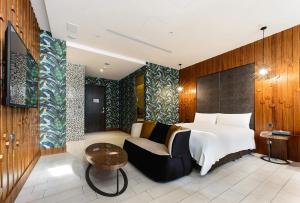 ein Schlafzimmer mit einem Bett, einem Stuhl und einem Tisch in der Unterkunft Norwegian Forest Leisure Motel in Taiping