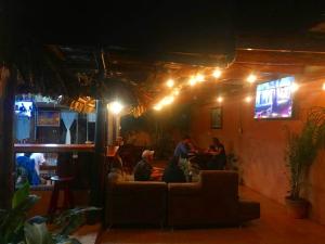 a group of people sitting in a living room at night at Hotel La Choza Inn in Fortuna