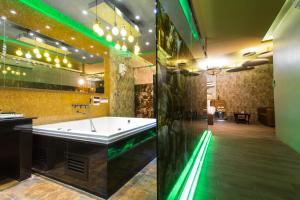 a large bathroom with a tub and green lighting at Sweety Resort in Bangna