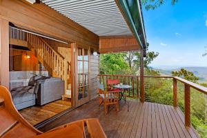 a house with a balcony with a couch and a table at The Polish Place in Mount Tamborine