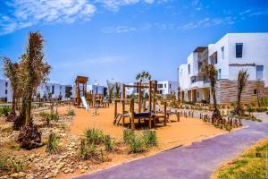 Beach Retreat Taghazout Bay في أغادير: حديقة بها ملعب مع زلاجة
