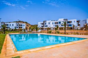 Beach Retreat Taghazout Bay في أغادير: مسبح امام بعض مباني الشقق