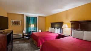 a hotel room with two beds and a flat screen tv at Osage Creek Lodge in Eureka Springs +16 photos