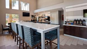 a bar with a white counter and bar stools at Best Western Apricot Inn in Chaney Ranch