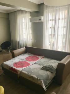 Una cama en una habitación con una colcha con rosas. en Cheap and Chic, en Batumi