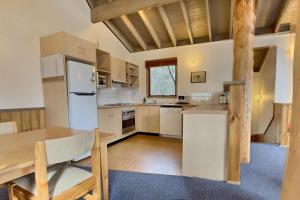 a kitchen with a white refrigerator and a wooden table at snowy river in Dinner Plain