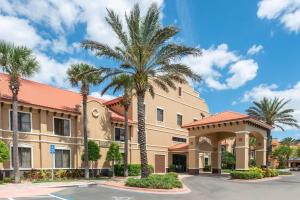 a hotel with palm trees in front of a building at Clarion Inn Ormond Beach at Destination Daytona in Ormond Beach