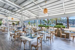 ポルト・デ・ソリェルにあるFERGUS Style Soller Beachのテーブルと椅子が備わるレストランで、水辺の景色を望めます。