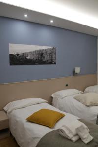 a room with two beds and a painting on the wall at Albergo Da Benedetta in Vetralla