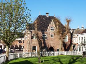 a large brick building with a white fence at het Binnenhuis in Workum