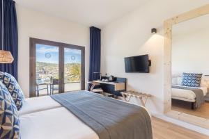 a hotel room with a bed and a balcony at FERGUS Style Soller Beach in Port de Soller