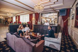 un grupo de personas sentadas en sofás en un restaurante en Hotel Barnaul, en Barnaul