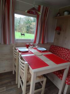 un comedor con una mesa y una vaca por la ventana en Roulotte Bigoudenne en Tréméoc