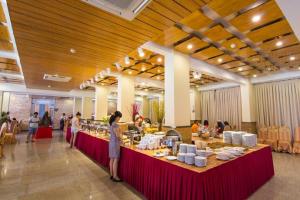 a group of people standing around a buffet in a building at New Wave Vung Tau Hotel in Vung Tau