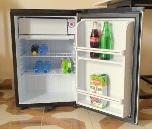 an open refrigerator with drinks and drinks in it at Eland Accommodations - Ongata Rongai in Ongata Rongai 