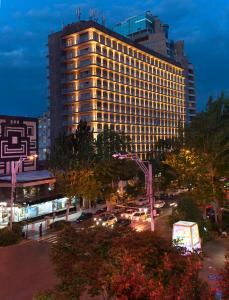 een hoog gebouw met auto's in een stad 's nachts bij Ani Plaza Hotel in Jerevan