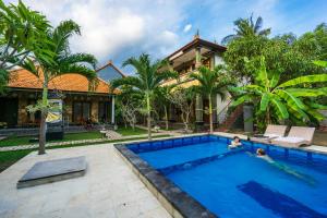 a villa with a swimming pool in front of a house at Arya Inn Enny Salon and Spa in Nusa Lembongan