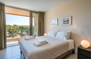 a bedroom with a large bed with a large window at Herdade dos Salgados Beach in Albufeira