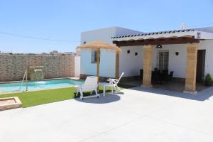 eine Villa mit einem Pool und einer Terrasse in der Unterkunft Chalet carril de los pareja in Conil de la Frontera