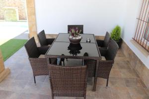 a dining room table with wicker chairs and a plant at Chalet carril de los pareja in Conil de la Frontera +23 photos