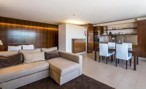 a living room with a couch and a dining room at Herdade dos Salgados Beach in Albufeira
