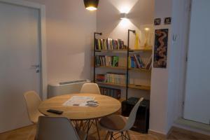 een kamer met een tafel en stoelen en een boekenplank bij Bed&Book in Matera