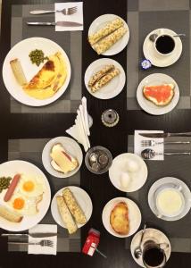 een tafel met witte borden met voedsel erop bij Dzhuliya Hotel in Akhtubinsk