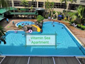 - une piscine avec un panneau indiquant la vitamine de l'appartement en bord de mer dans l'établissement 2 mins to beach Apartment 3 rooms, à Kampong Pasir Bogak