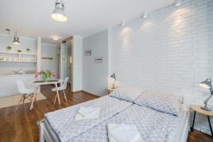 a bedroom with a white brick wall and a bed at Studio Skwer Kościuszki in Gdynia