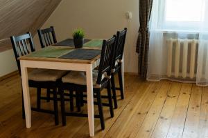 uma mesa de jantar e cadeiras com uma planta em At the Trakai Castle em Trakai