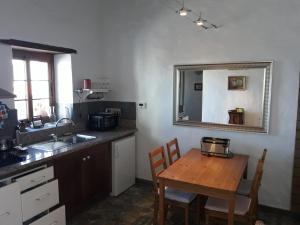 a kitchen with a wooden table and a mirror at Finca La Ramona in Isora