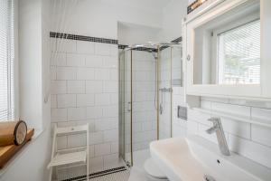 baño blanco con ducha y lavamanos en Studio - Grandtulipan, en Gdynia