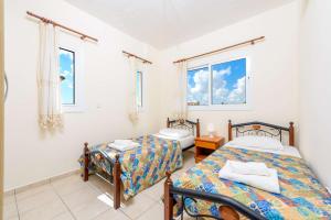 2 camas en una habitación con 2 ventanas en Villa Di Gio, en Paralimni