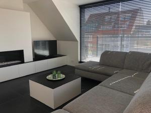 een woonkamer met een bank en een tv bij Soetkin in Knokke-Heist