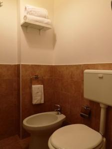 a bathroom with a toilet and a sink and towels at B&B Oltrelmar in Matino