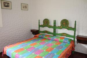 a green bed with a colorful comforter in a bedroom at VILLA CARLA in Numana