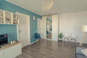 uma sala de estar com televisão e paredes azuis em Luna Apartment em Constança